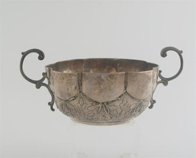 Appraisal: A lobed circular bowl with twin upswept scroll handles and