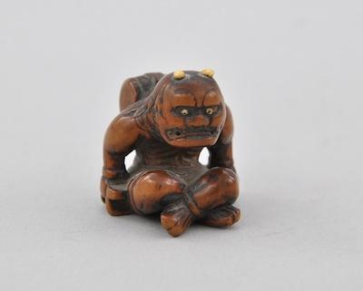 Appraisal: A Seated Oni Netsuke Carved wood with inset bone or