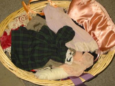 Appraisal: A basket of dolls clothing including velvet cotton and crepe