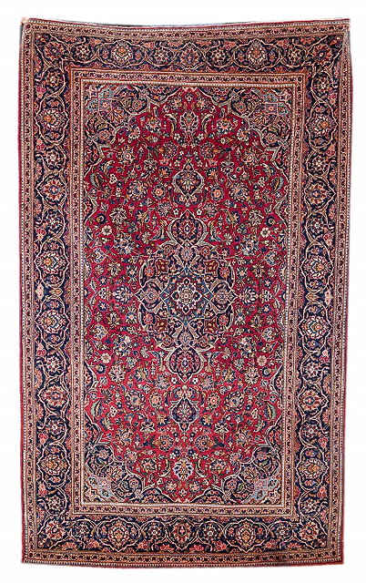 Appraisal: A PERSIAN KASHAN RED GROUND RUG with a central blue