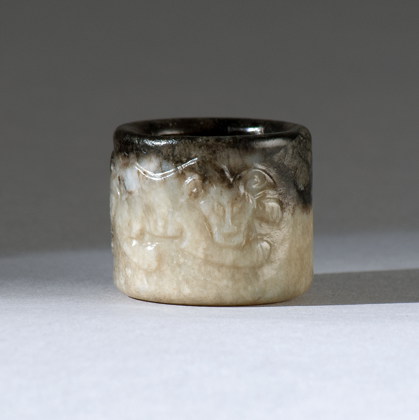 Appraisal: BLACK AND WHITE JADE THUMB RING Circa With relief qilin