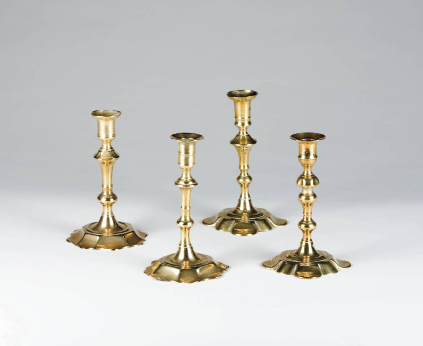 Appraisal: FOUR SIMILAR GEORGE II OR III BRASS CANDLESTICKS MID-EIGHTEENTH CENTURY