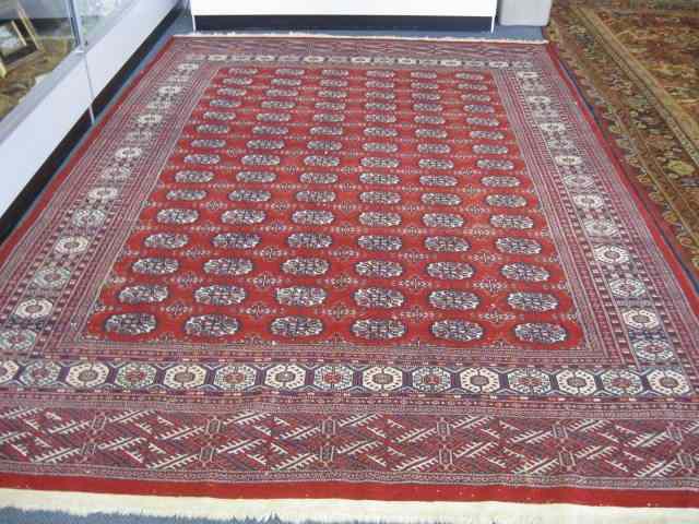 Appraisal: Bokara Handmade Rug reds blues ivory geometric designs ' ''