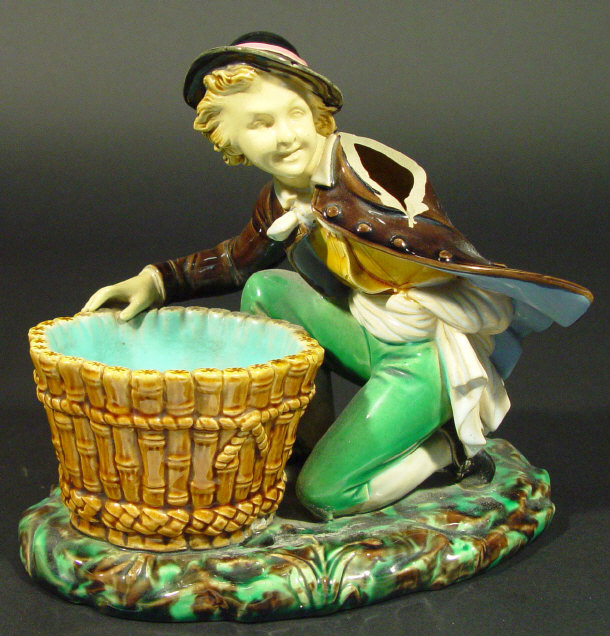 Appraisal: Victorian Majolica figure crouching beside an open basket decorated in