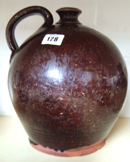 Appraisal: A Sussex ware pottery flagon with brown treacle glaze decoration