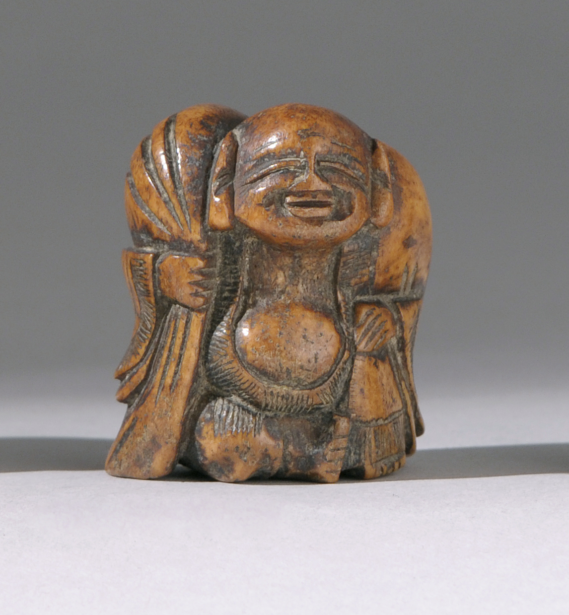 Appraisal: BONE NETSUKE Early th CenturyIn the form of Hotei carrying