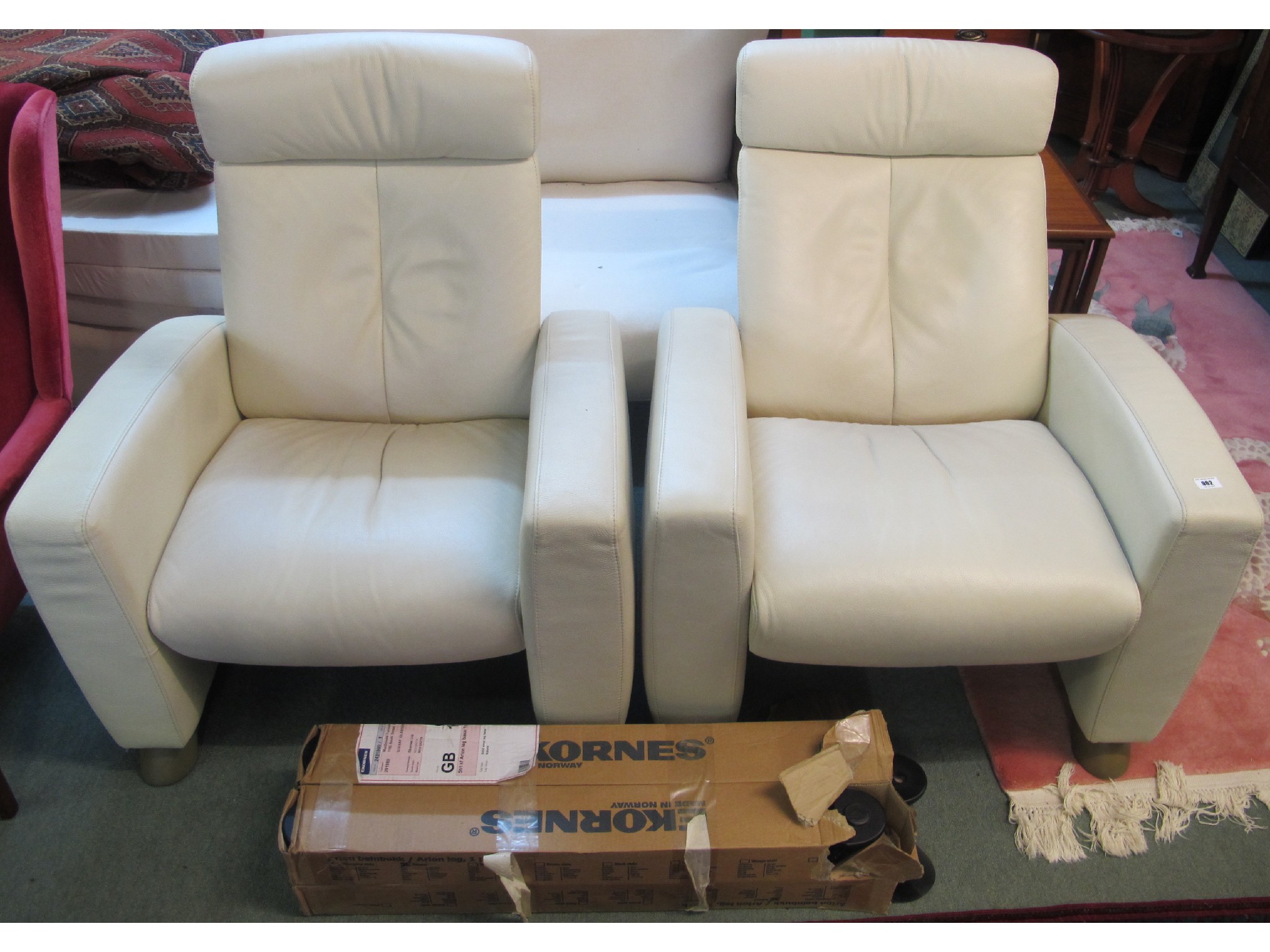 Appraisal: A pair of faux cream leather Ekornes reclining chairs