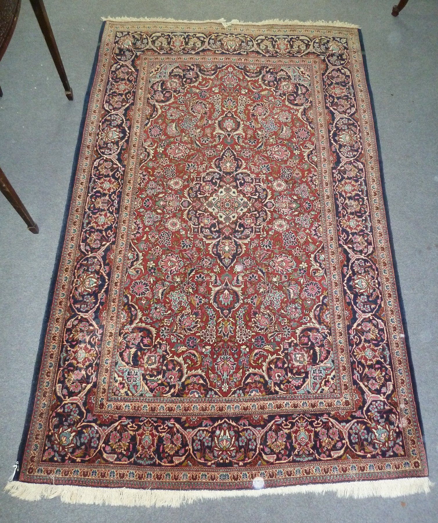 Appraisal: A Kashan rug with central red ground floral field within