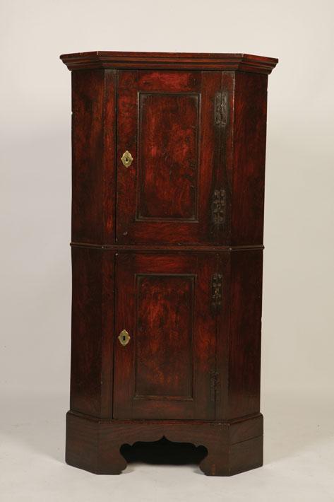 Appraisal: A PRIMITIVE ELM DOUBLE CORNER CUPBOARD with twin panelled doors