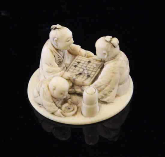 Appraisal: A Japanese ivory netsuke of two seated men playing 'go'