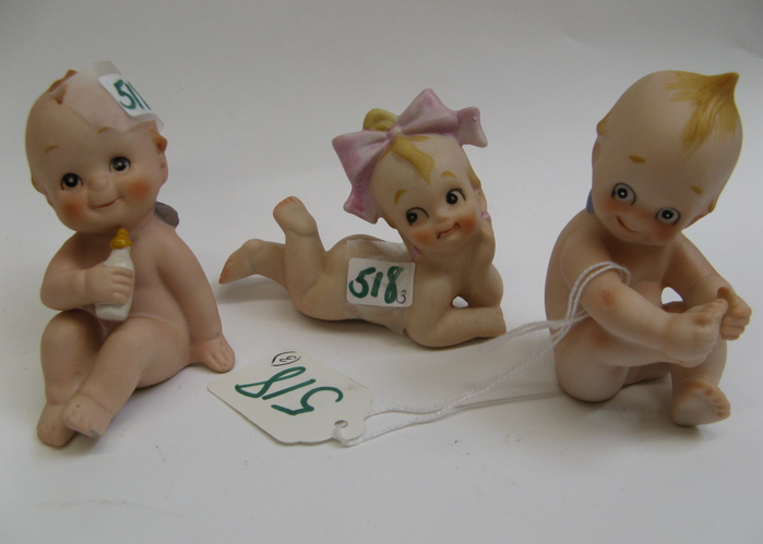 Appraisal: THREE KEWPIE BISQUE FIGURINES with painted hair and features smiling