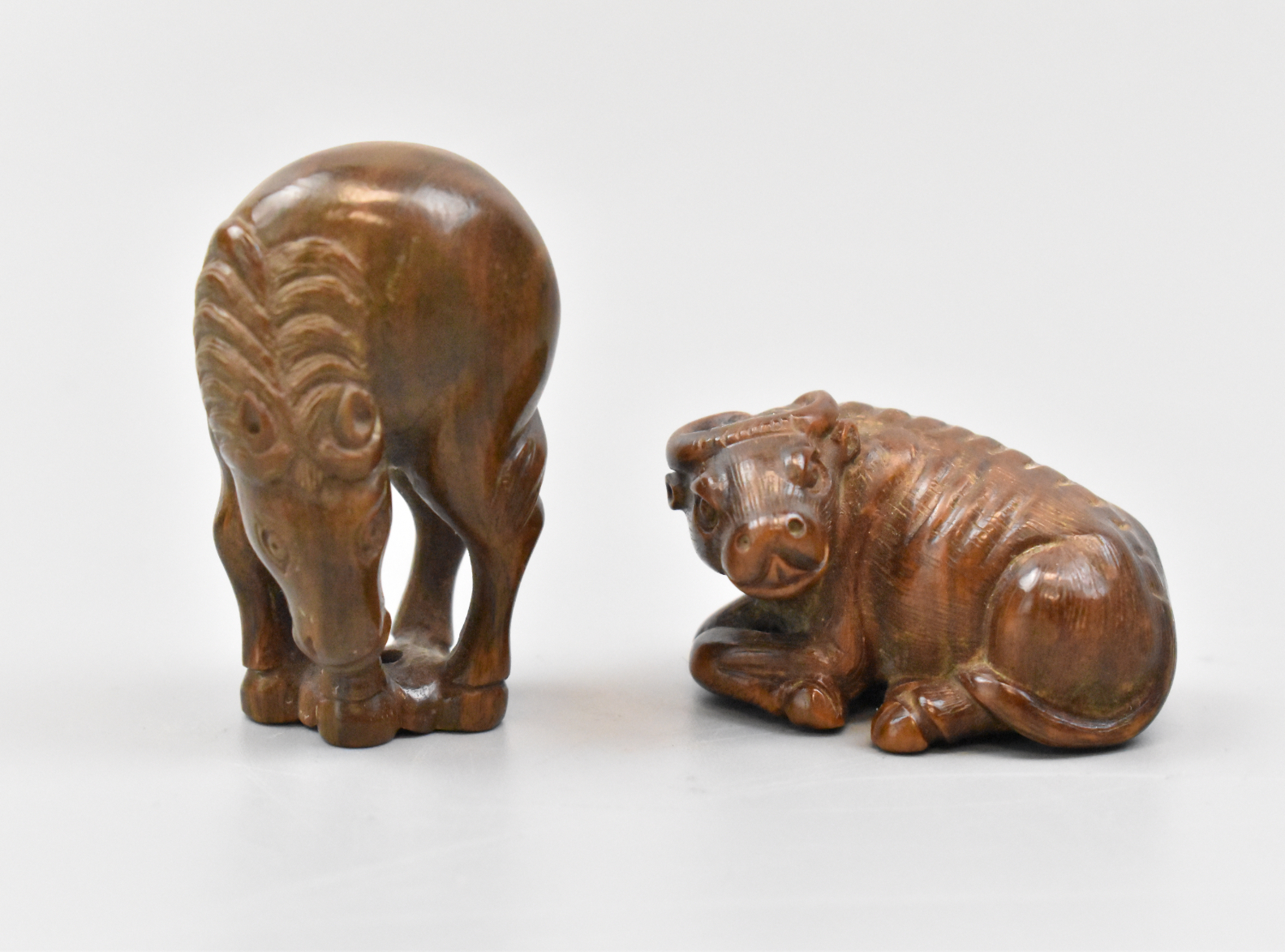 Appraisal: Two Japanese Netsuke carved animals a horse and buffalo dating