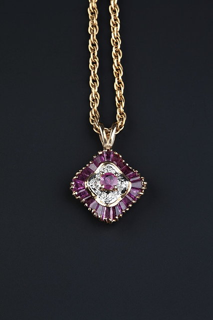 Appraisal: A RUBY AND DIAMOND SET PENDANT the undulating panel set