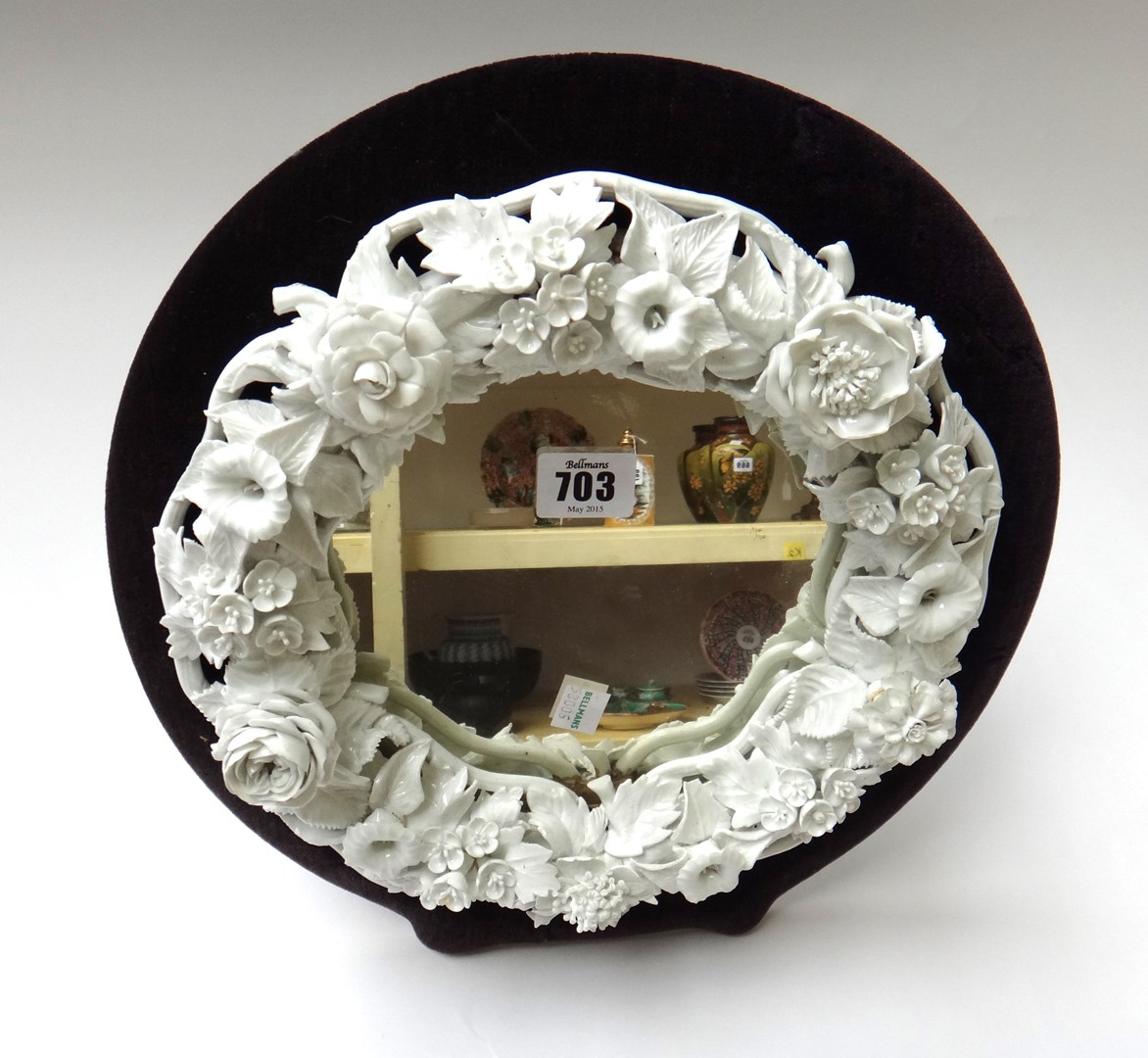 Appraisal: A white glazed porcelain strut back mirror the circular border