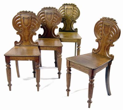 Appraisal: Four carved oak hall chairs the shaped backs with vacant