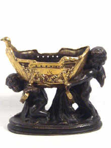 Appraisal: A brass group of two cherubs supporting a cradle