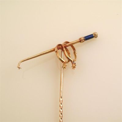 Appraisal: A gold stick pin with a riding crop and a