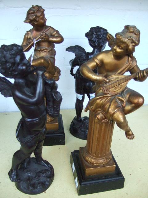 Appraisal: Two gilt spelter cherubic figures modelled seated atop fluted columns