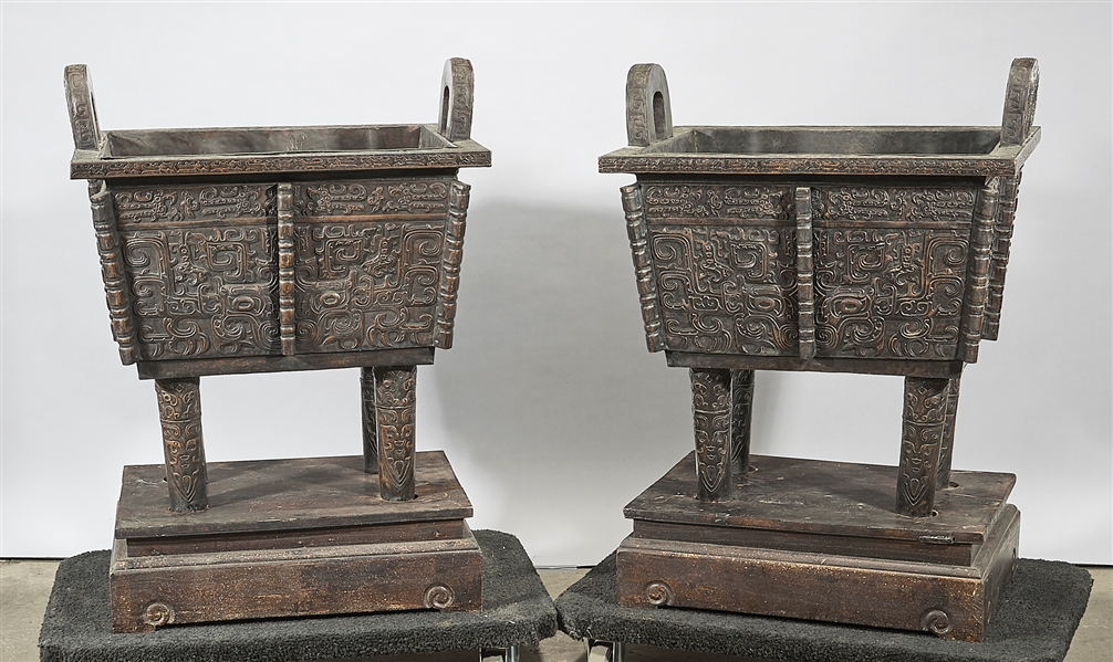 Appraisal: Pair of Chinese hollow metal archaistic ding vessels wood stands