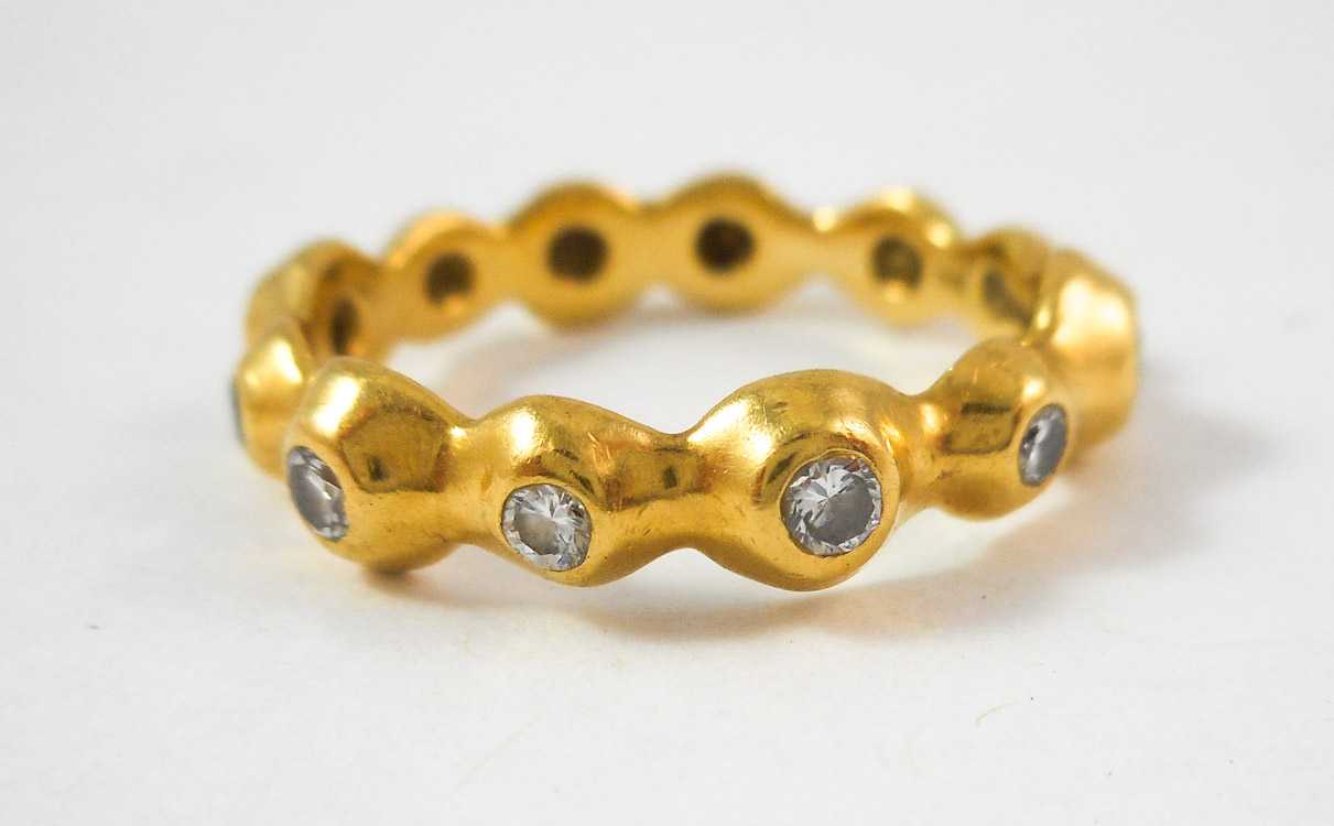 Appraisal: DIAMOND AND EIGHTEEN KARAT GOLD ETERNITY RING bezel set with