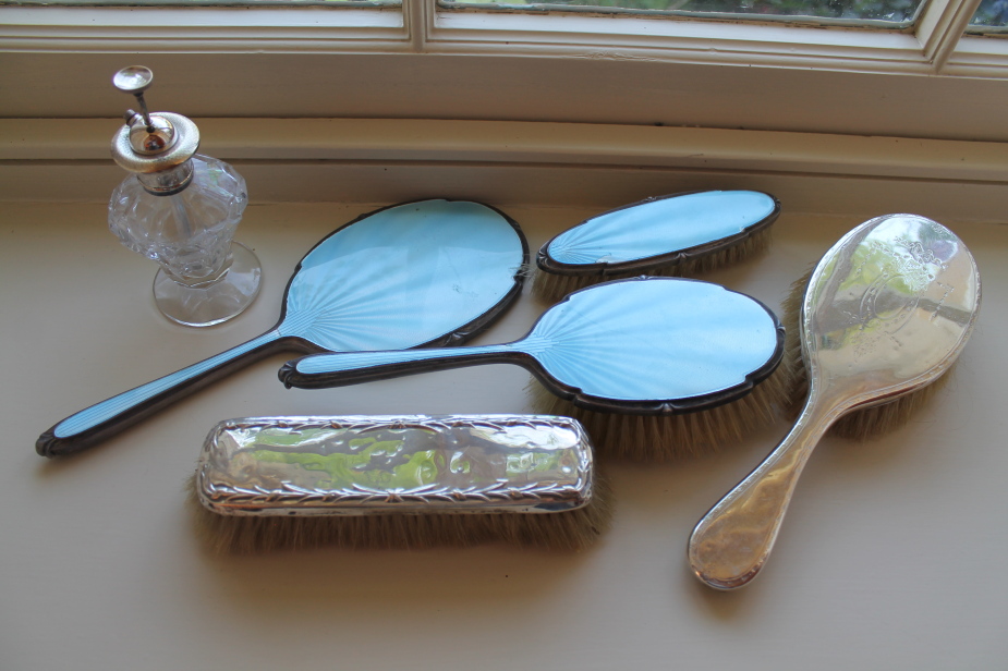 Appraisal: A silver and blue enamelled toilet mirror and brushes two