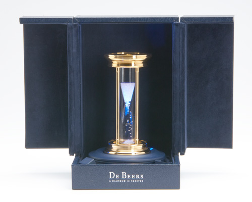 Appraisal: DeBeers Starburst Diamonds diamond hourglass in case with self-illuminating stand