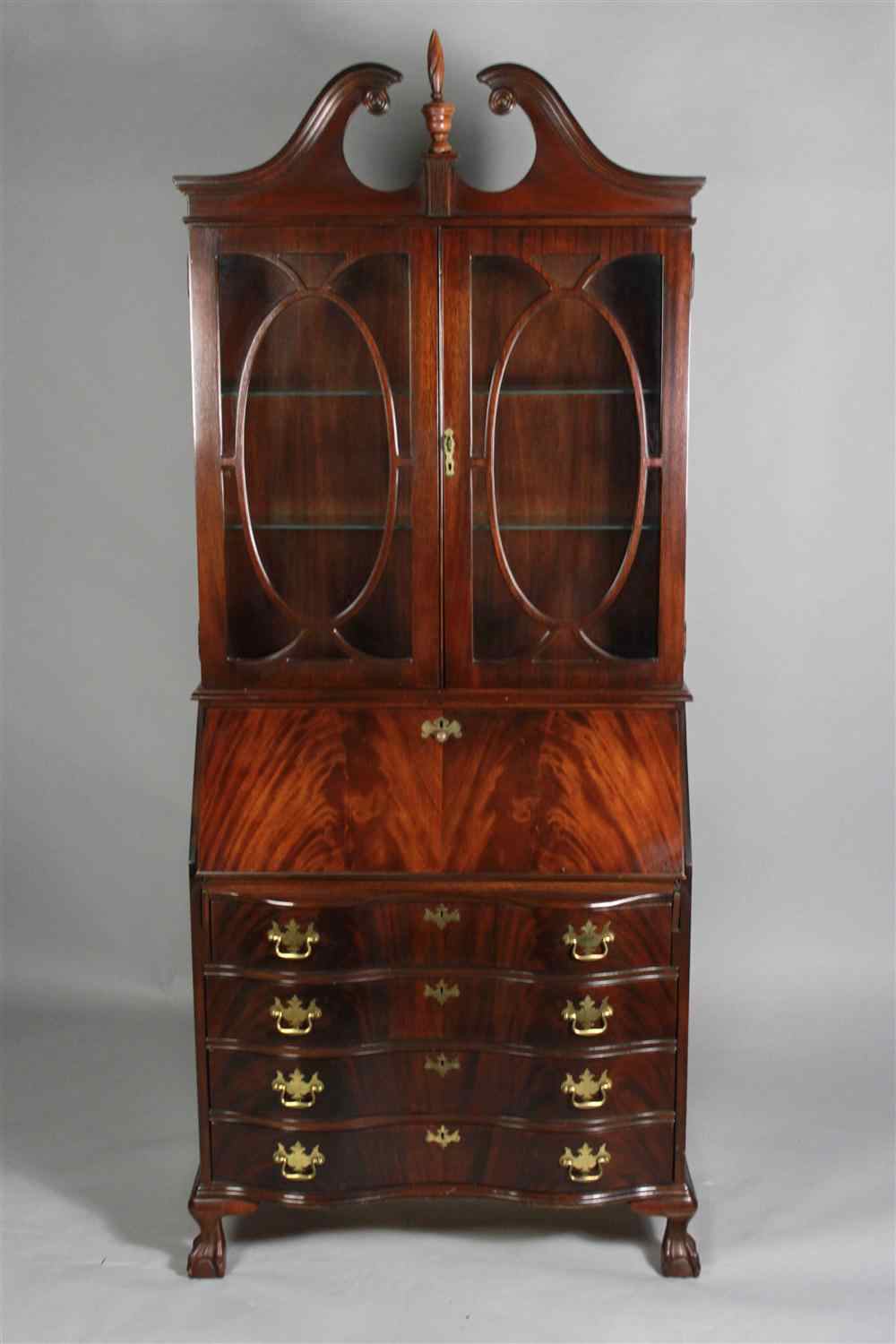 Appraisal: JASPER CHIPPENDALE STYLE MAHOGANY SECRETARY the scrolled broken pediment centered