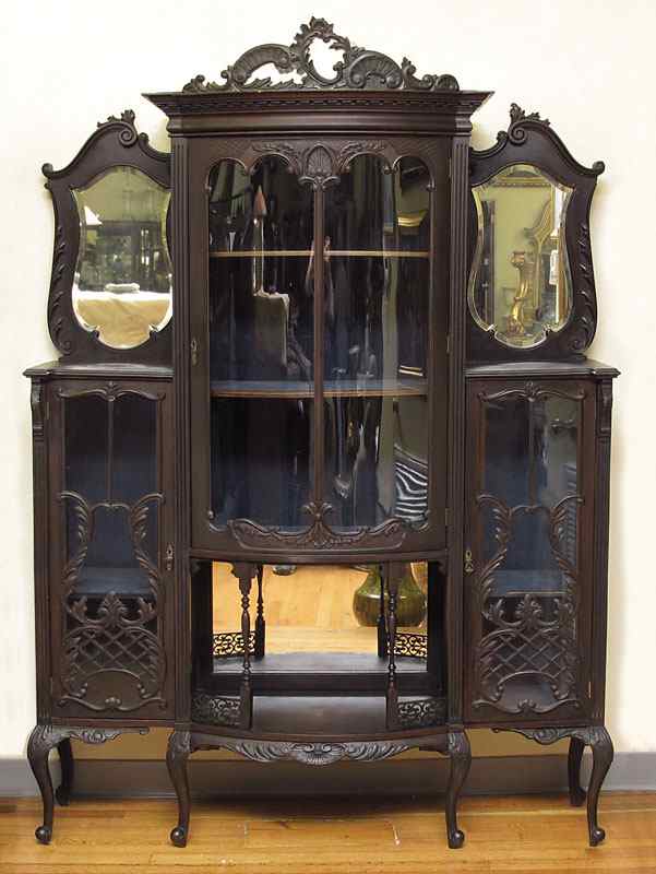 Appraisal: CARVED EDWARDIAN ETAGERE Foliate scroll crest over glass front center