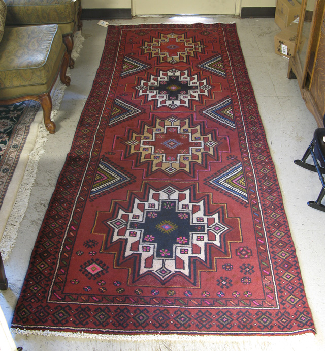 Appraisal: PERSIAN TRIBAL AREA RUG the plain plum ground featuring four