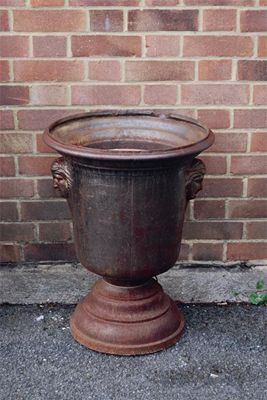 Appraisal: A French cast iron lemon tree urn with mask lifts