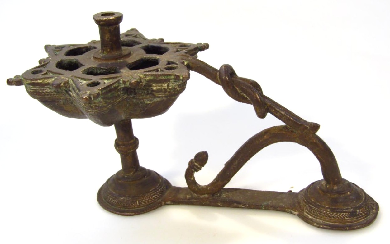 Appraisal: A Middle Eastern metal candlestick with floral pierced dish holder