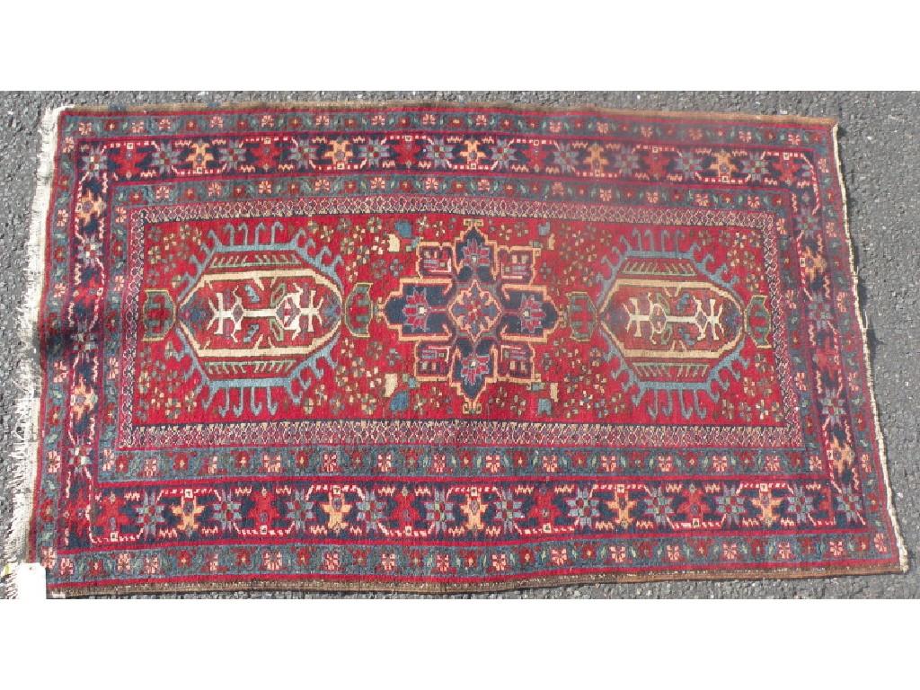 Appraisal: A Persian rug with three medallions on a red ground