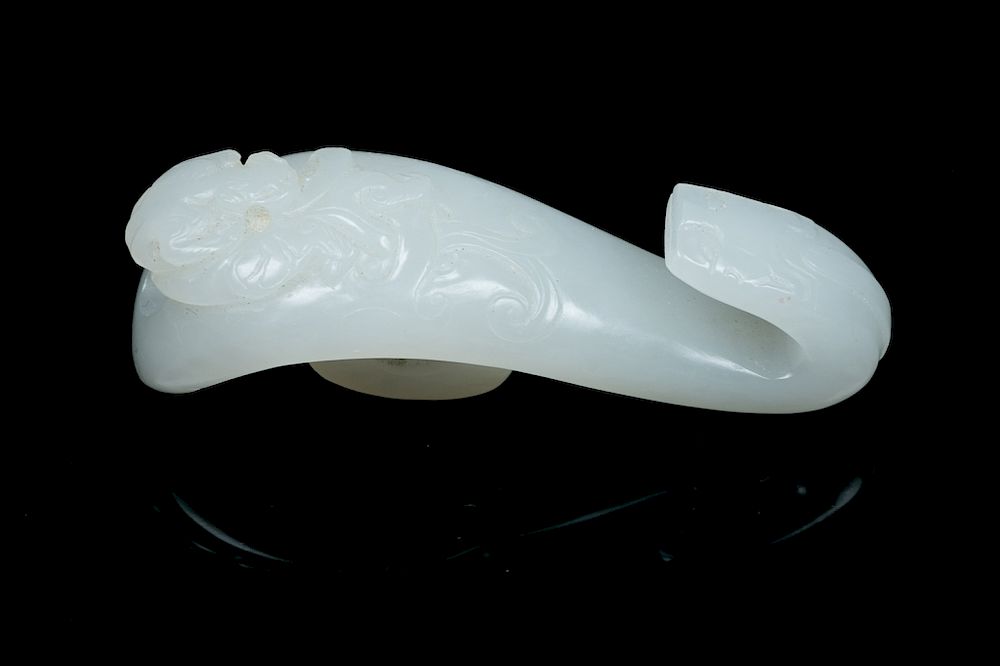 Appraisal: A WHITE JADE 'DRAGON' HOOK QING The white jade hook