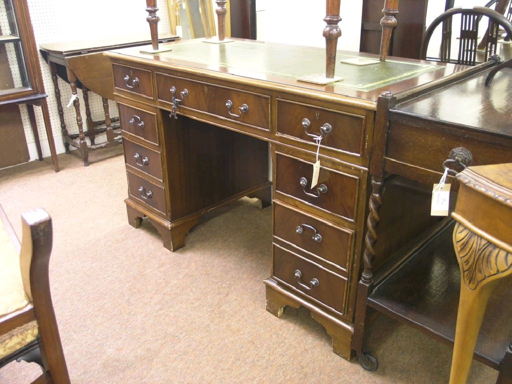 Appraisal: A reproduction mahogany veneered desk inset green leather top above