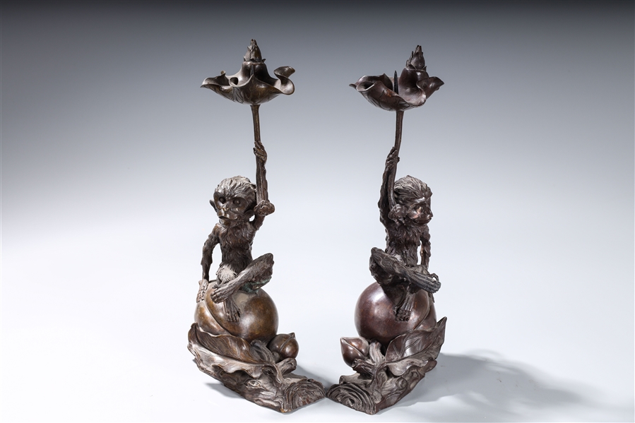 Appraisal: Pair of Chinese bronze candlesticks each of a monkey sitting