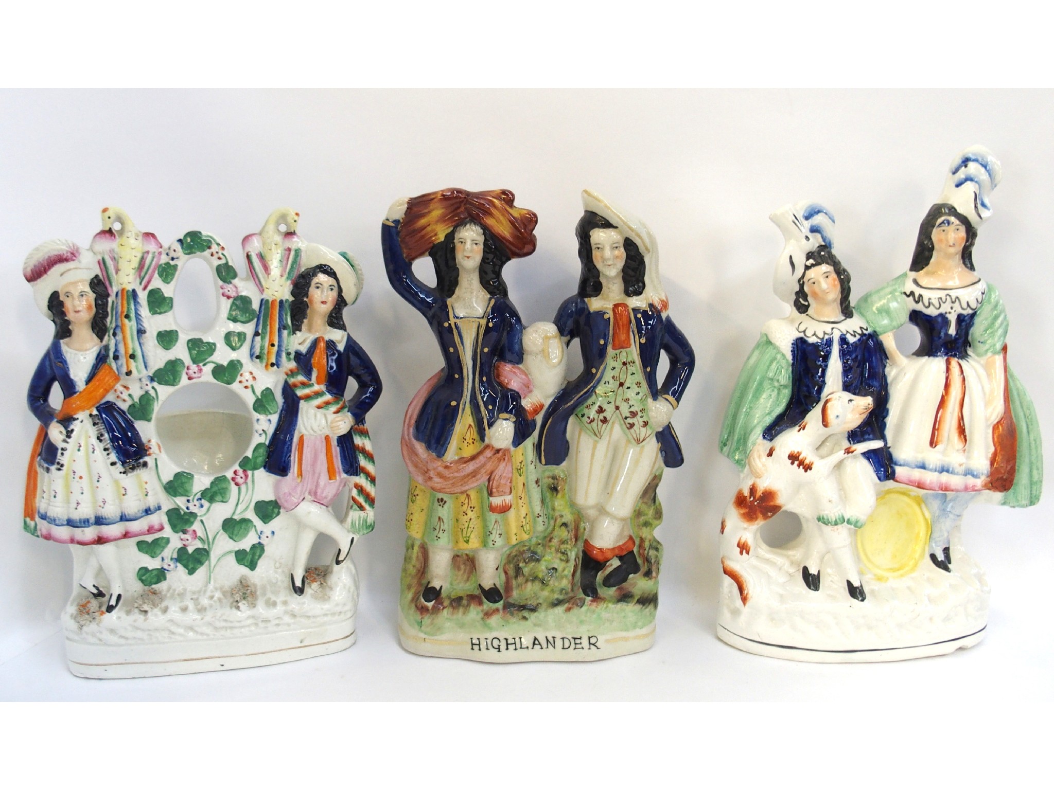 Appraisal: Three Staffordshire figure groups including a watch holder Highlander etc