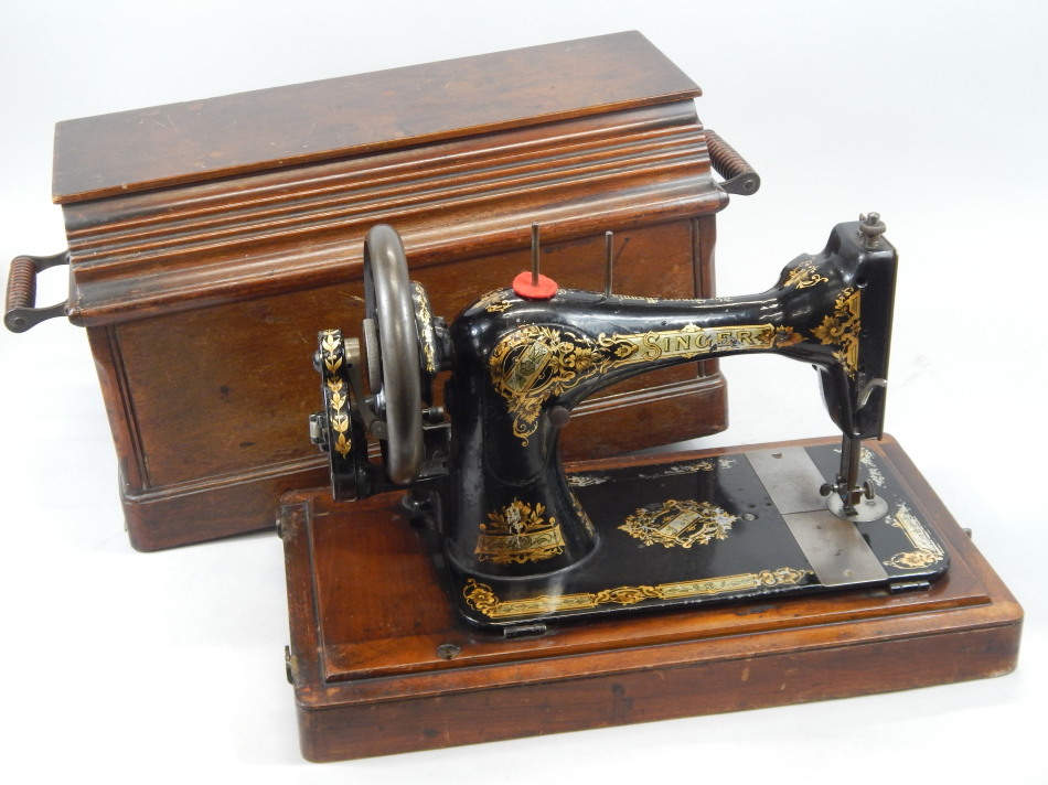 Appraisal: A Singer sewing machine in a walnut case with accessories