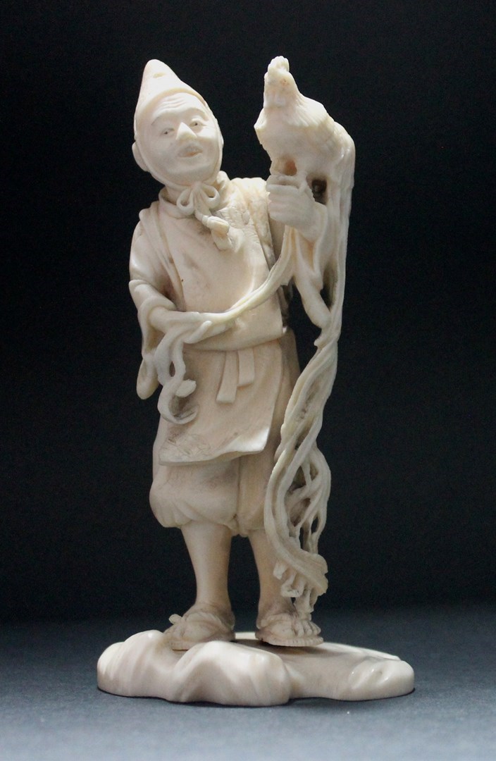 Appraisal: A Japanese ivory netsuke of a man Meiji period standing