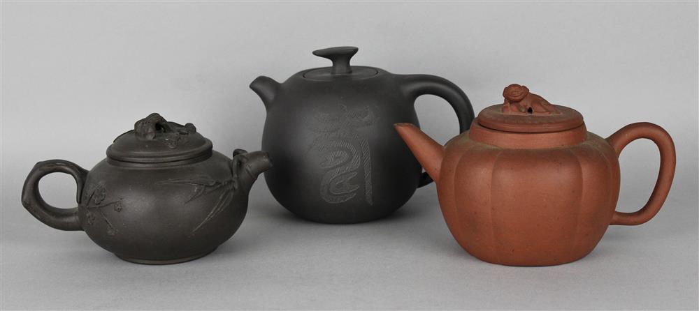 Appraisal: THREE CHINESE XIYING TEAPOTS the first of dark greyish-brown clay