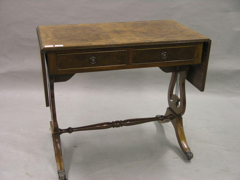 Appraisal: A reproduction burr walnut veneered sofa table with two frieze