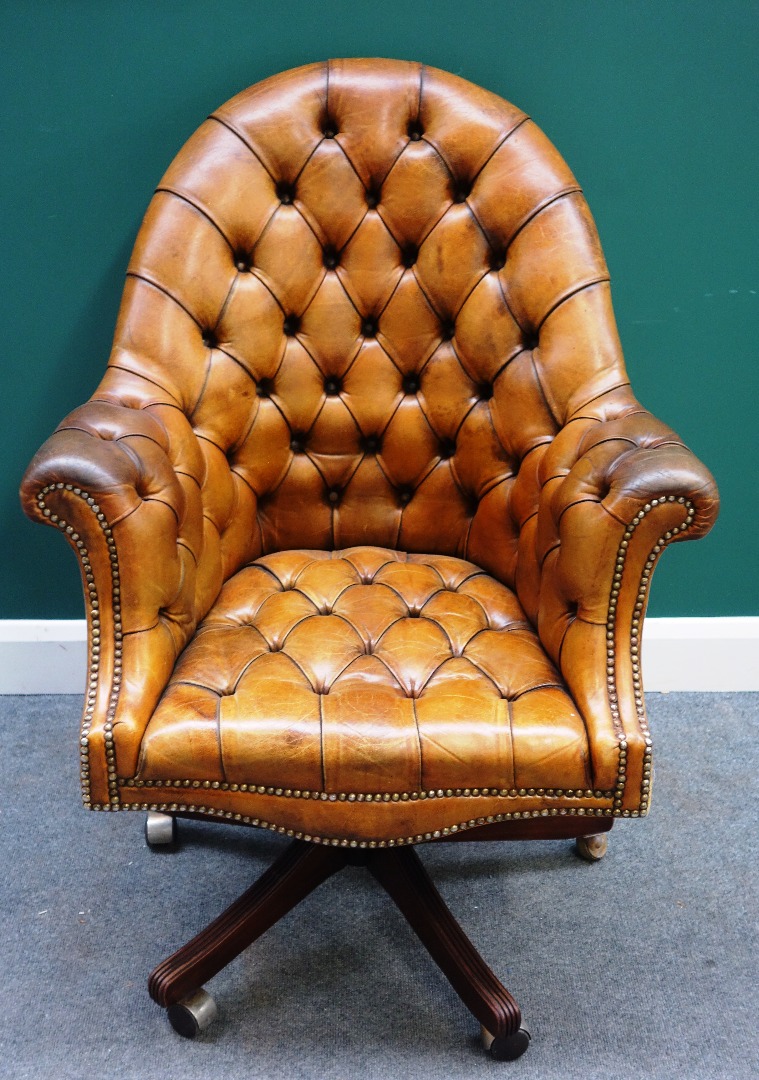 Appraisal: A th century studded brown leather office tub back swivel