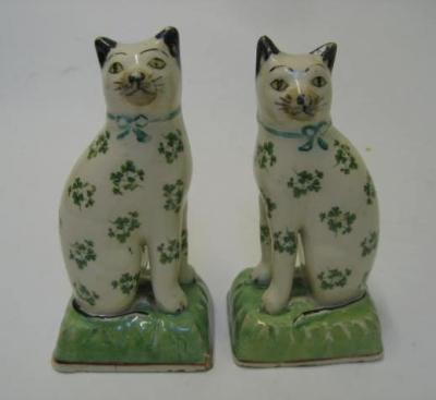 Appraisal: A PAIR OF STAFFORDSHIRE POTTERY CATS late th century modelled