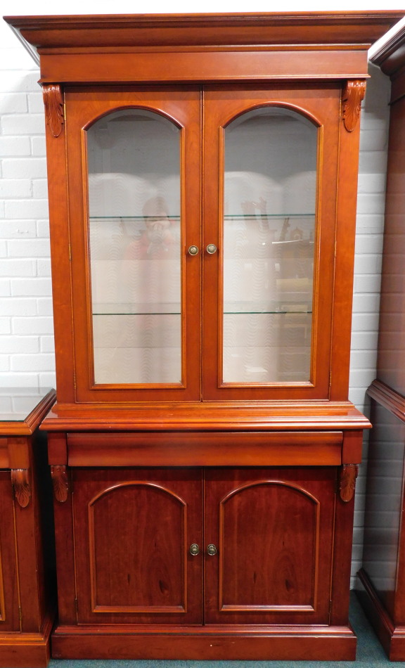 Appraisal: A Victorian style cherry bookcase with overhanging cornice raised above