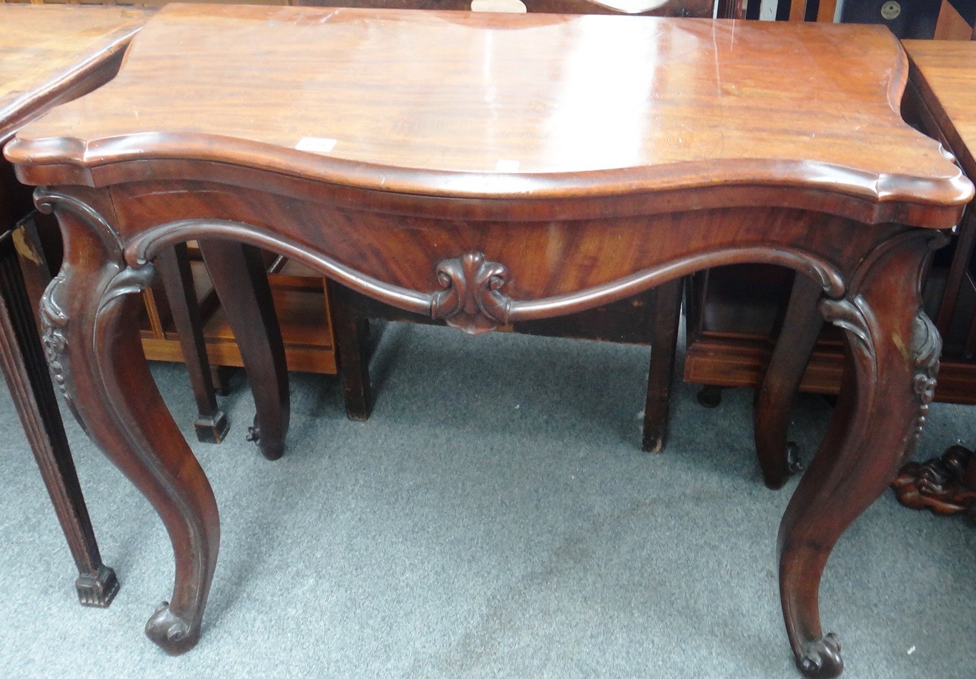 Appraisal: A Victorian mahogany serpentine tea table on carved cabriole supports