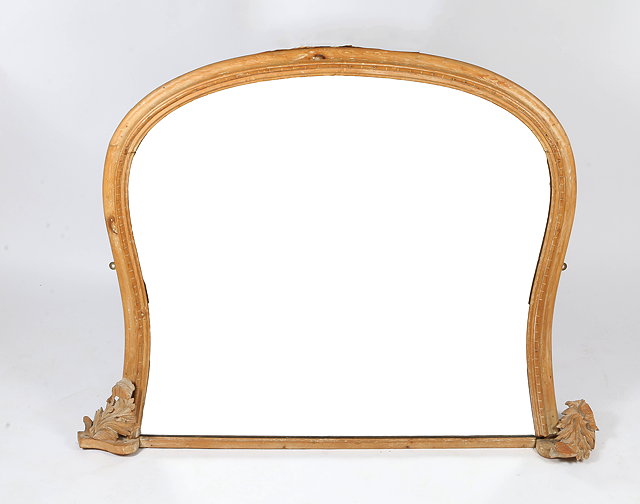 Appraisal: A STRIPPED PINE OVERMANTEL MIRROR of shaped outline with carved