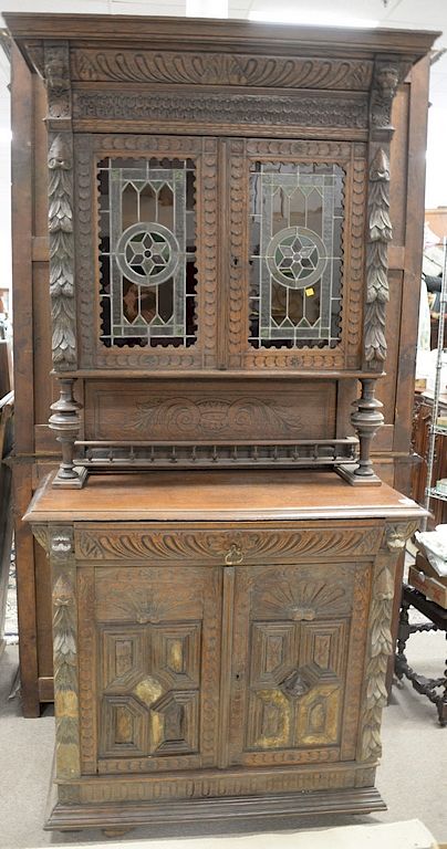 Appraisal: Victorian large carved oak two part cabinet having colored leaded