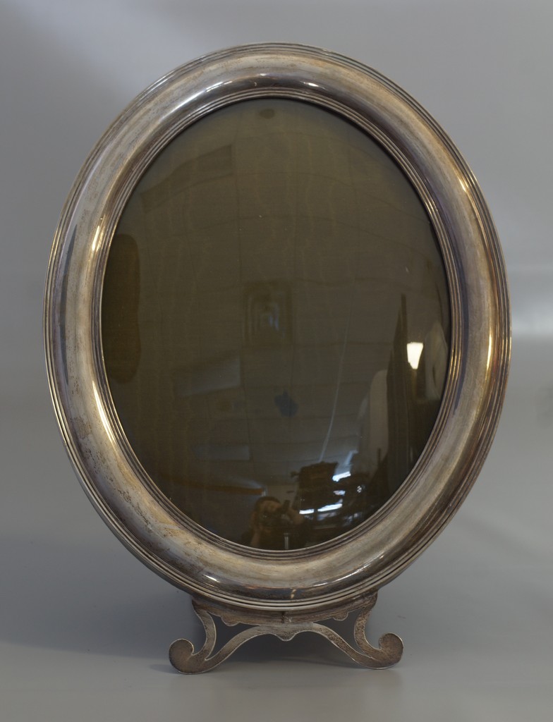 Appraisal: Oval sterling silver frame with easel back convex glass TO