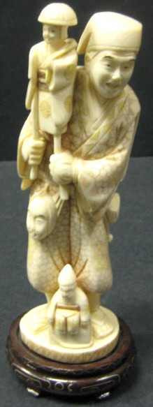 Appraisal: JAPANESE CARVED IVORY FIGURE OF A PUPETEER Standing with puppets