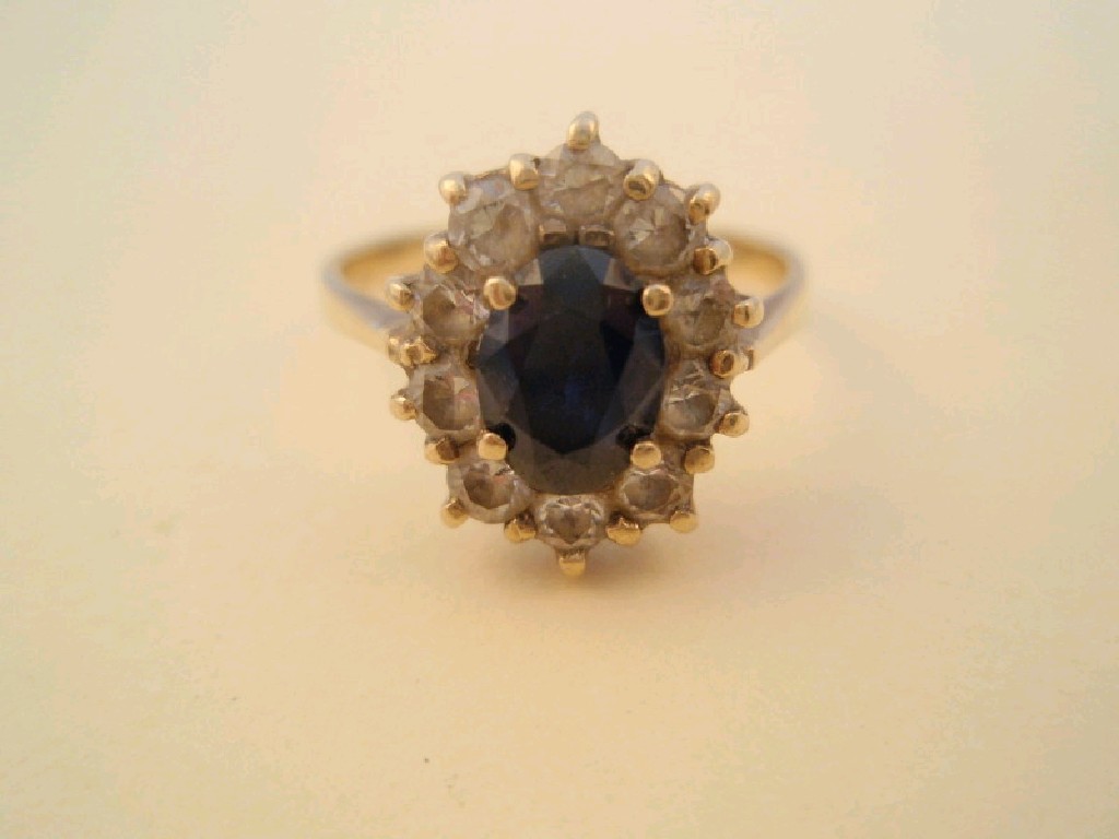 Appraisal: An oval sapphire and white stone set cluster ring