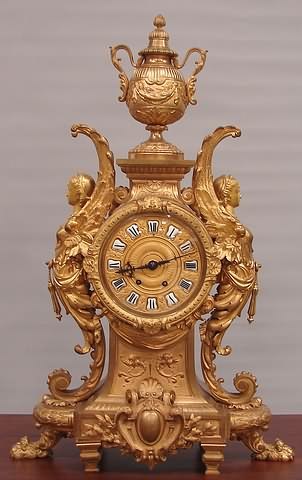 Appraisal: Winged female figures supporting center clock works and dial surrmounted